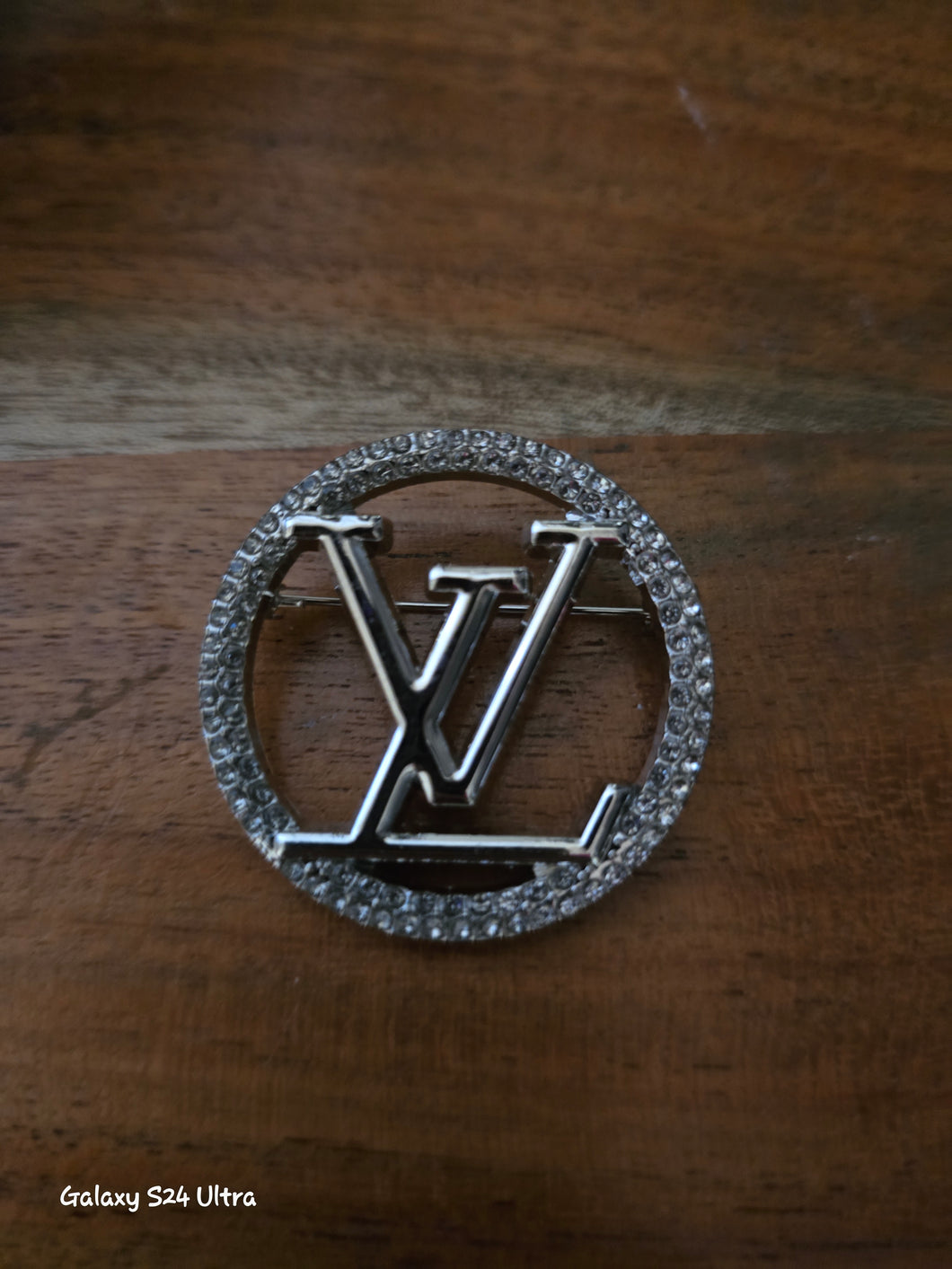 LV silver tone brooch