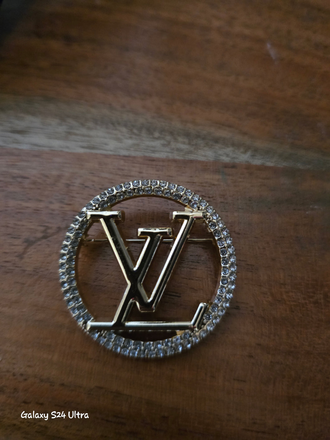 Lv gold tone brooch